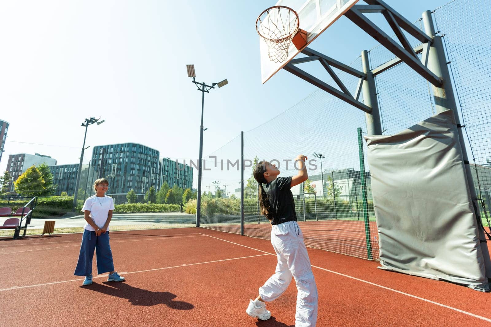 Children and sports. Teenage girl playing basketball on the playground. High quality photo