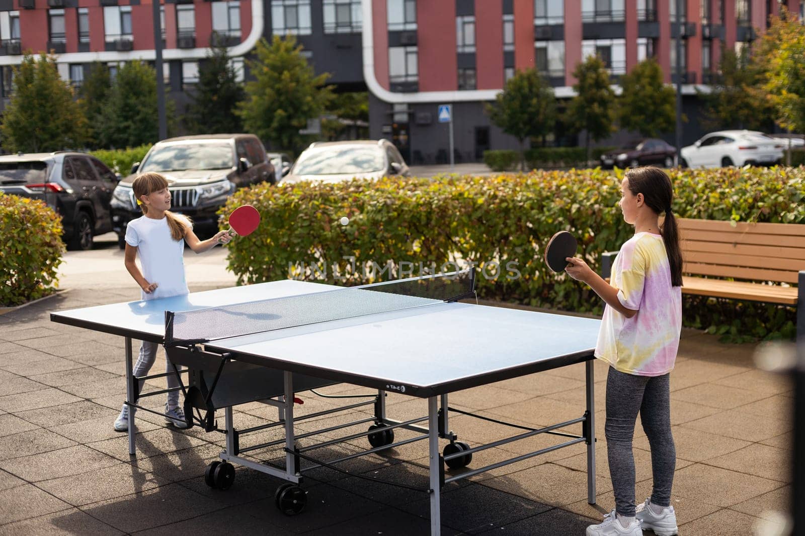 Little children playing ping pong in park. High quality photo