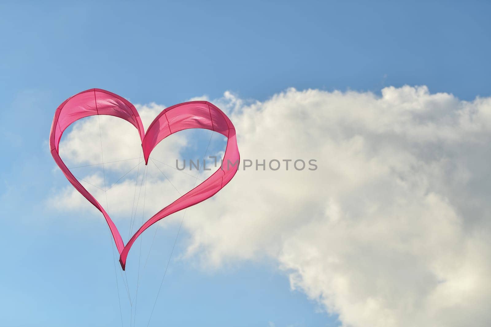 Pink heart kite is flying in the sky