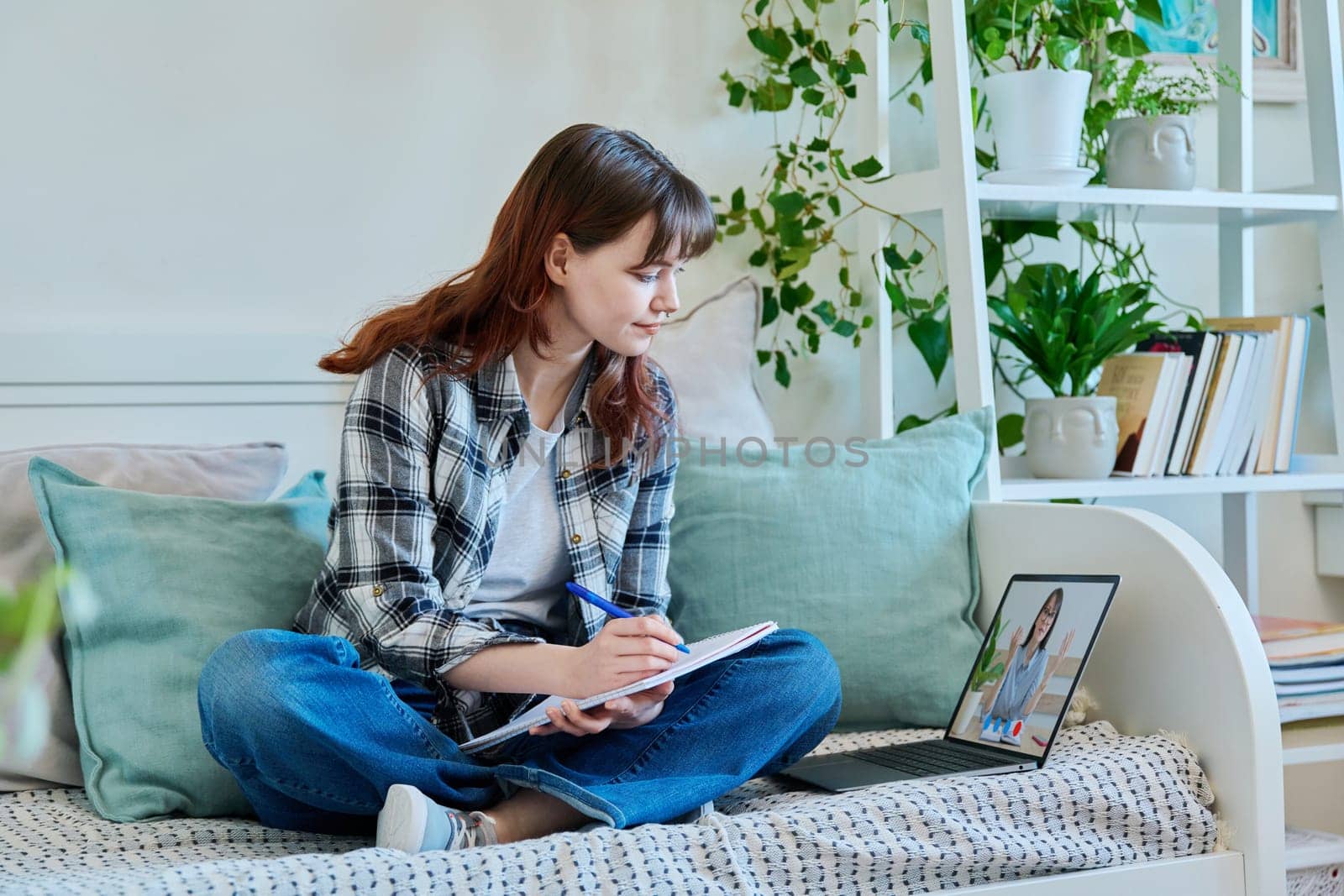 Girl college student watching educational webinar, sitting at home with laptop by VH-studio