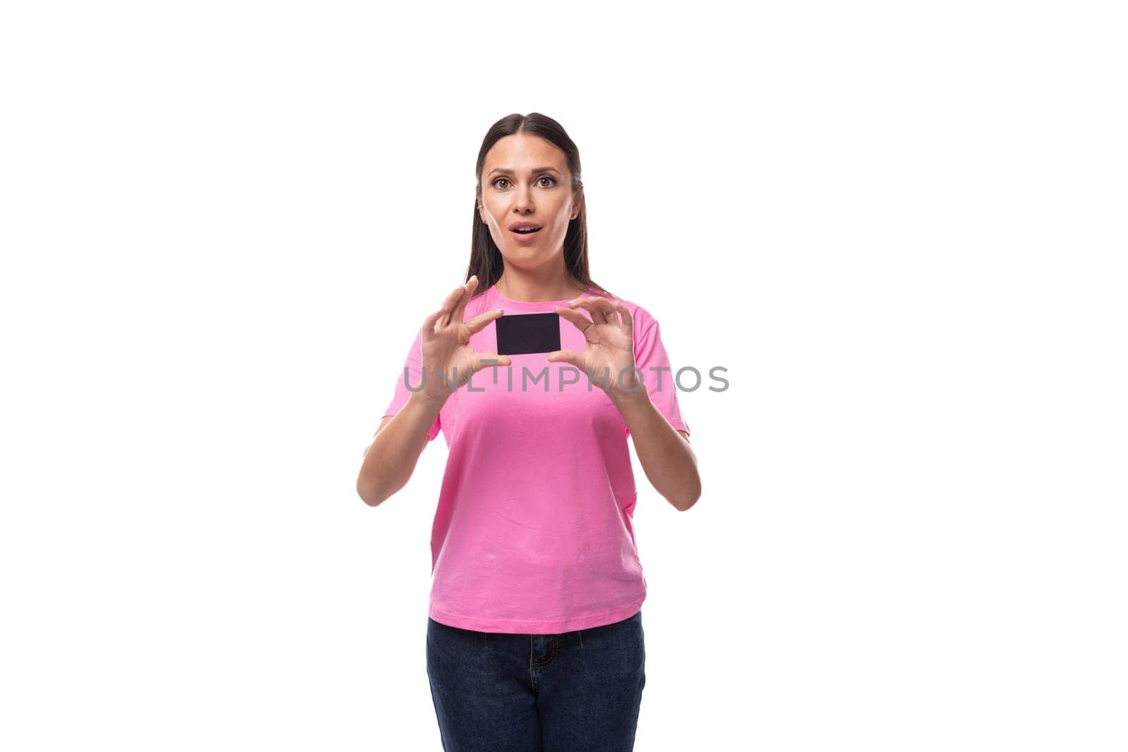 young stylish woman with straight black hair dressed in a pink t-shirt holding a credit card with mockup.