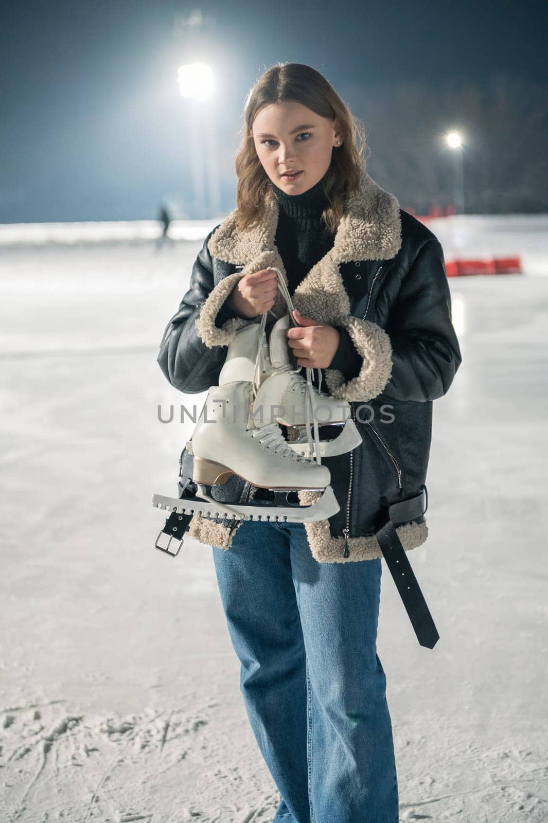 Beautiful young woman ice skating by rusak