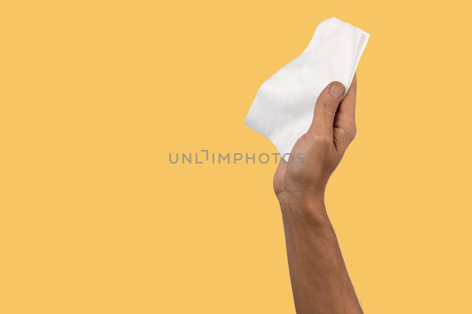 Black male hand holding a dust cleaning cloth isolated on yellow background. High quality photo