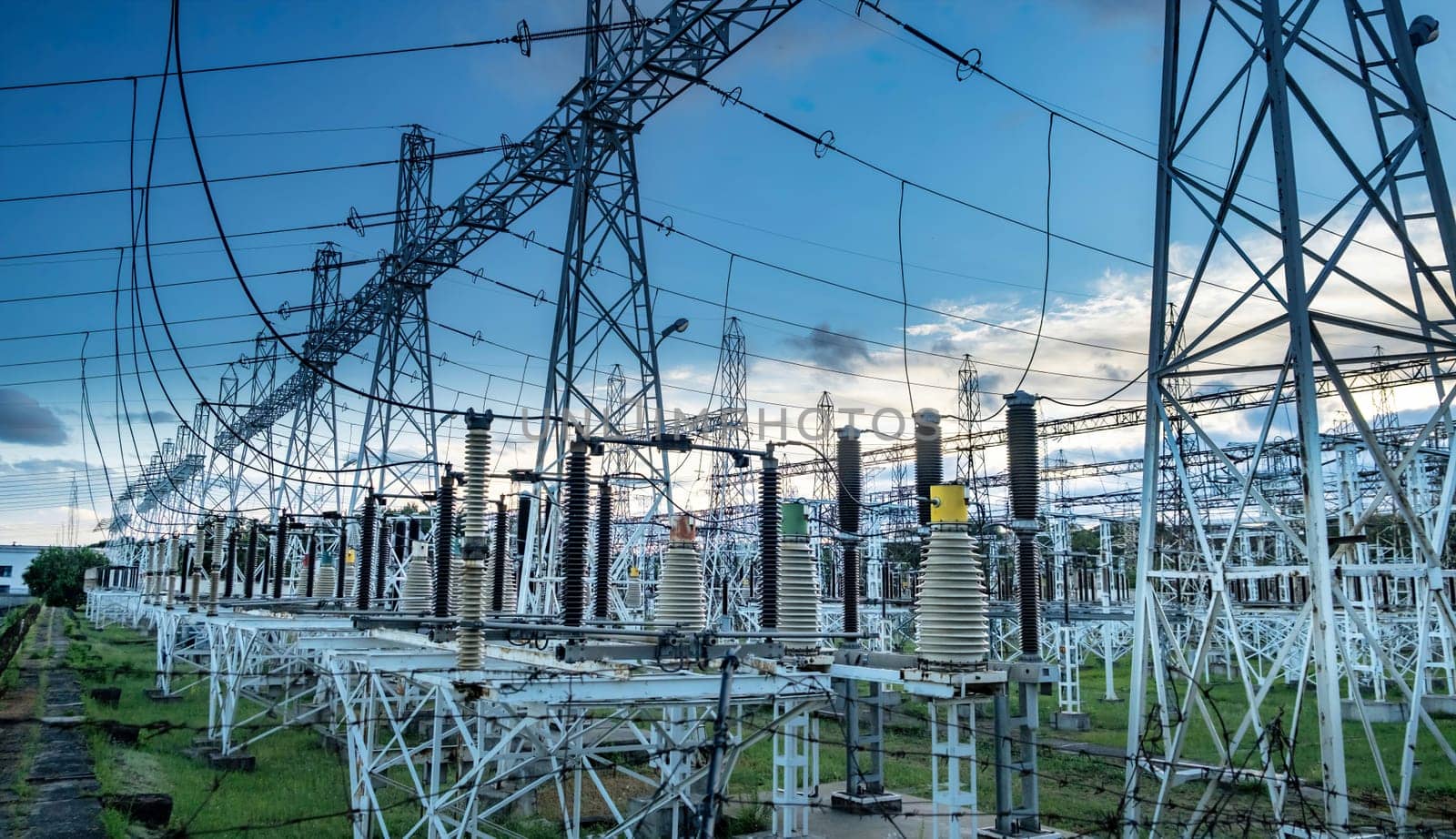 High voltage power transformer substation before russian bombed on Ukraine territory. High voltage tower with blue sky and sunset. by igor010