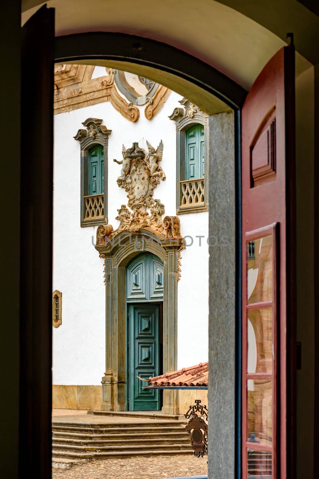 Baroque church front seen through the window of an old colonial-style house in the city of Mariana in Minas Gerais