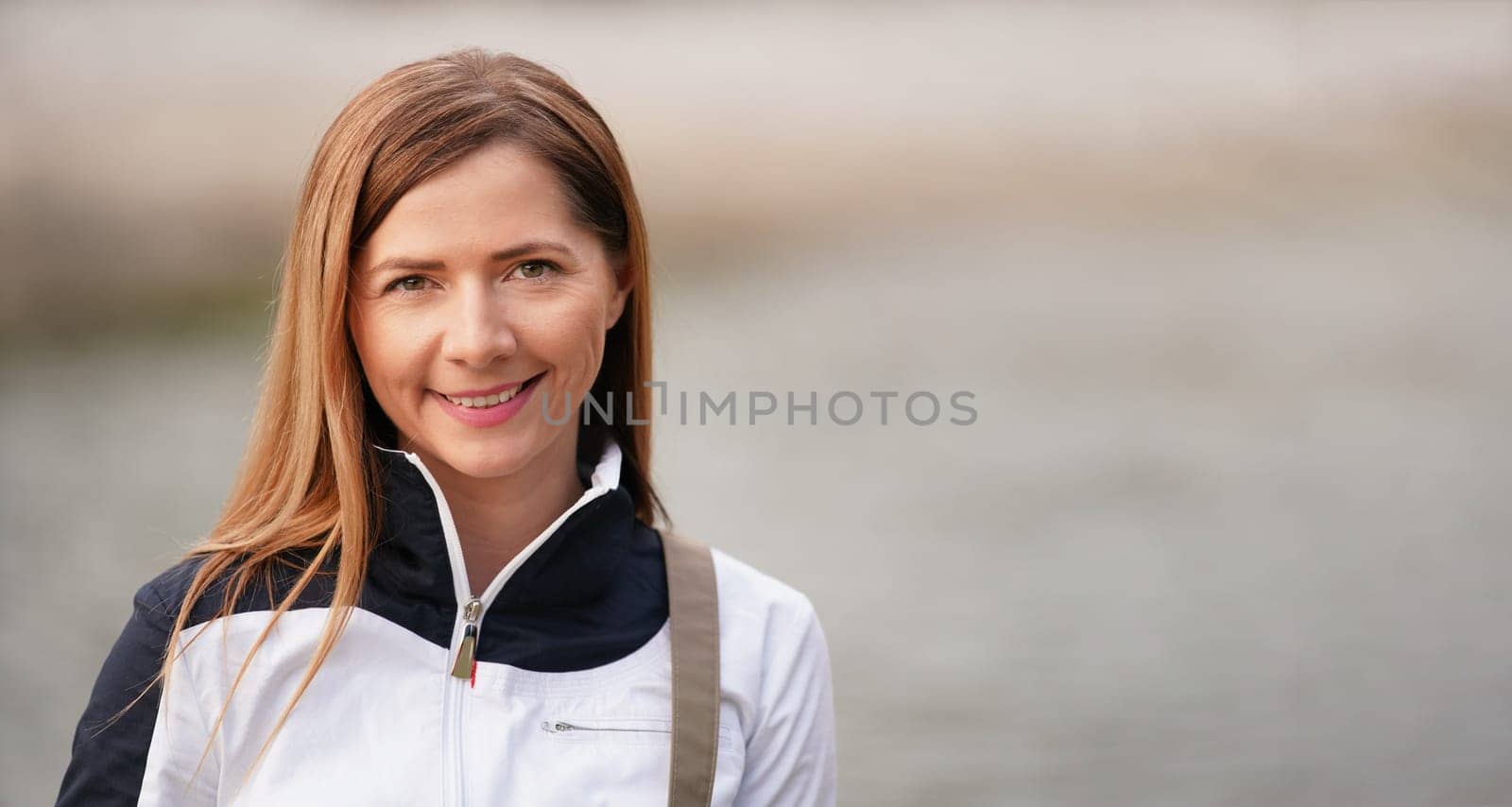 Portrait of young brunette woman smiling, blurred background (empty space for text) behind her