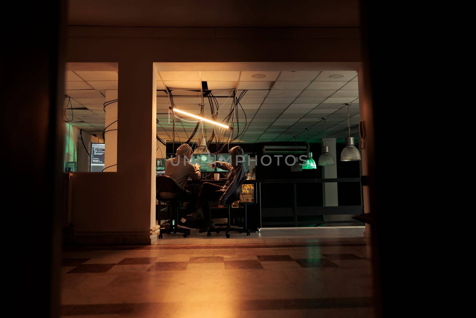 Diverse team of thieves coding trojan virus late at night by DCStudio