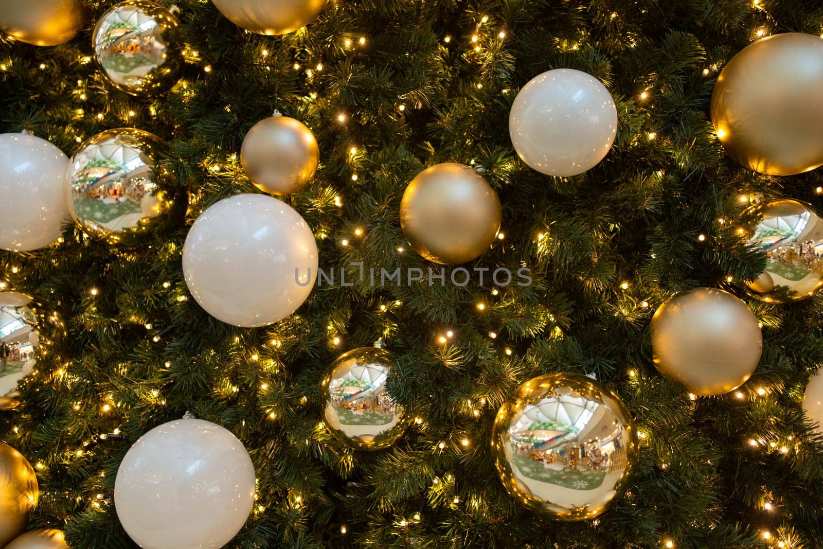 Closeup of Christmas tree decorated with shiny balls and fairy lights by andreonegin