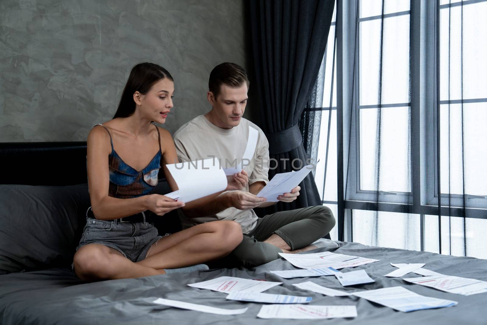 Stress young family couple worried about credit card bill. Unveiling by biancoblue