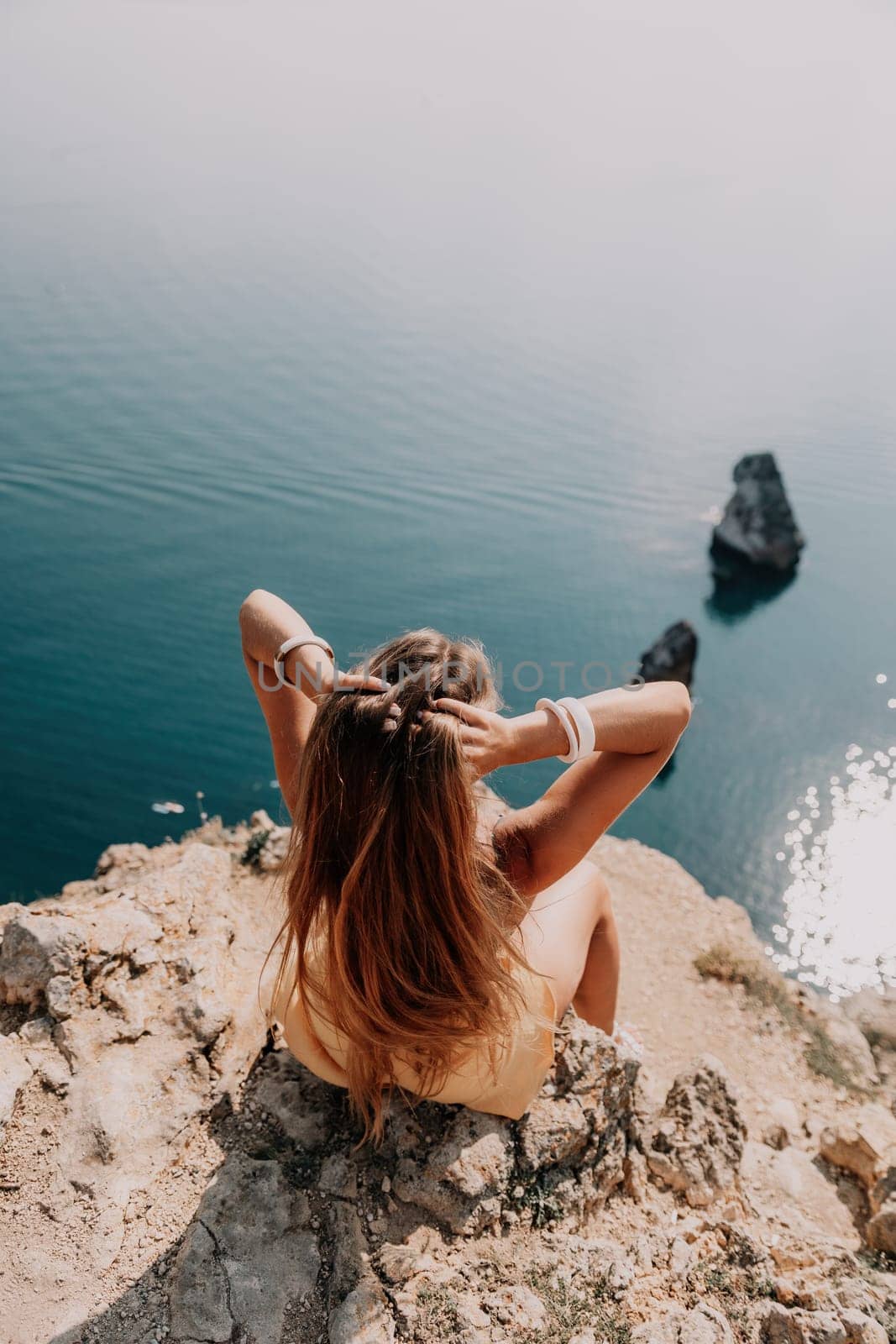 Woman travel sea. Happy tourist enjoy taking picture outdoors for memories. Woman traveler looks at the edge of the cliff on the sea bay of mountains, sharing travel adventure journey by panophotograph