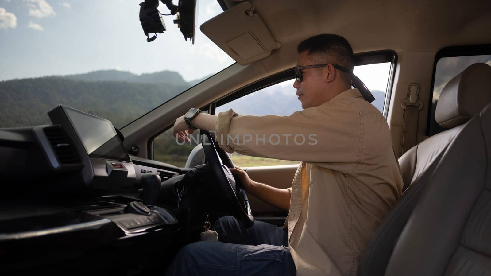Man in sunglasses driving on holiday adventure. Road trip, traveling and lifestyle concept.