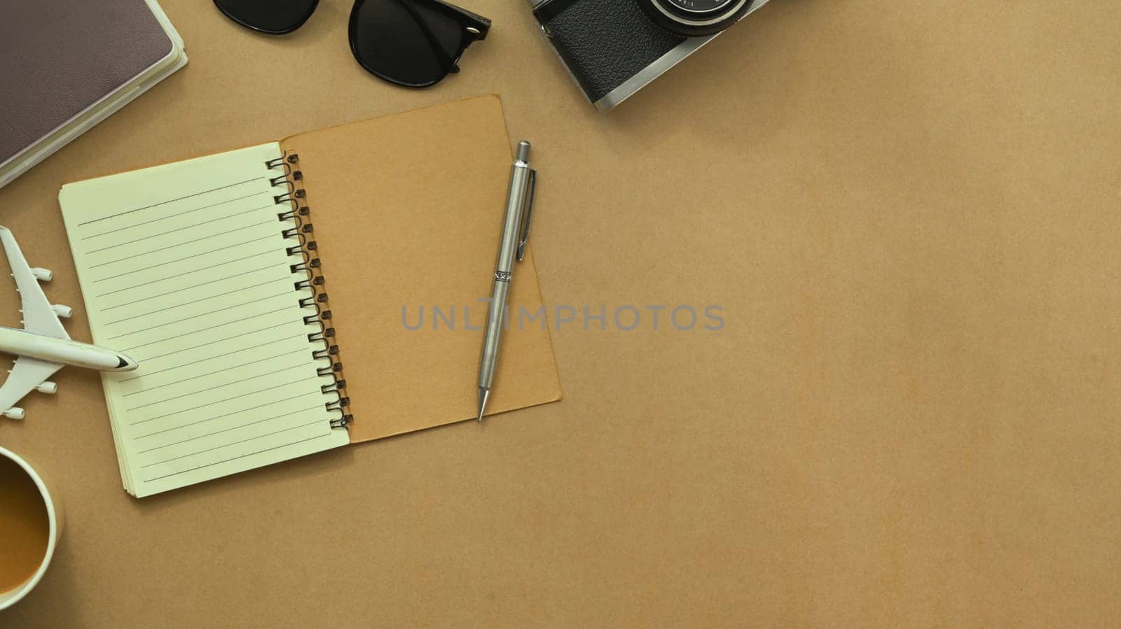 Blank notepad and traveler accessories on brown background. Travel and vacation concept.