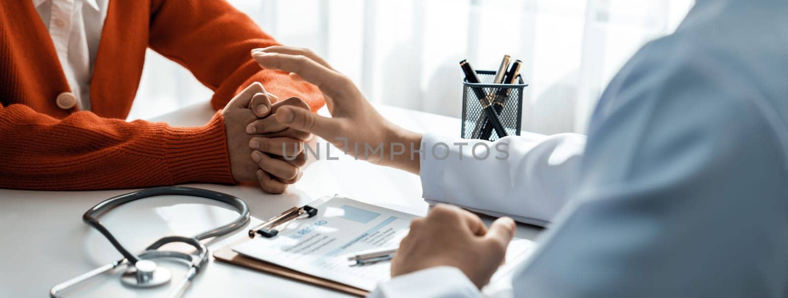 Patient attend doctor's appointment at clinic or hospital office, discussing medical treatment option and explaining diagnostic result while consoling and comforting patient. Panorama Rigid