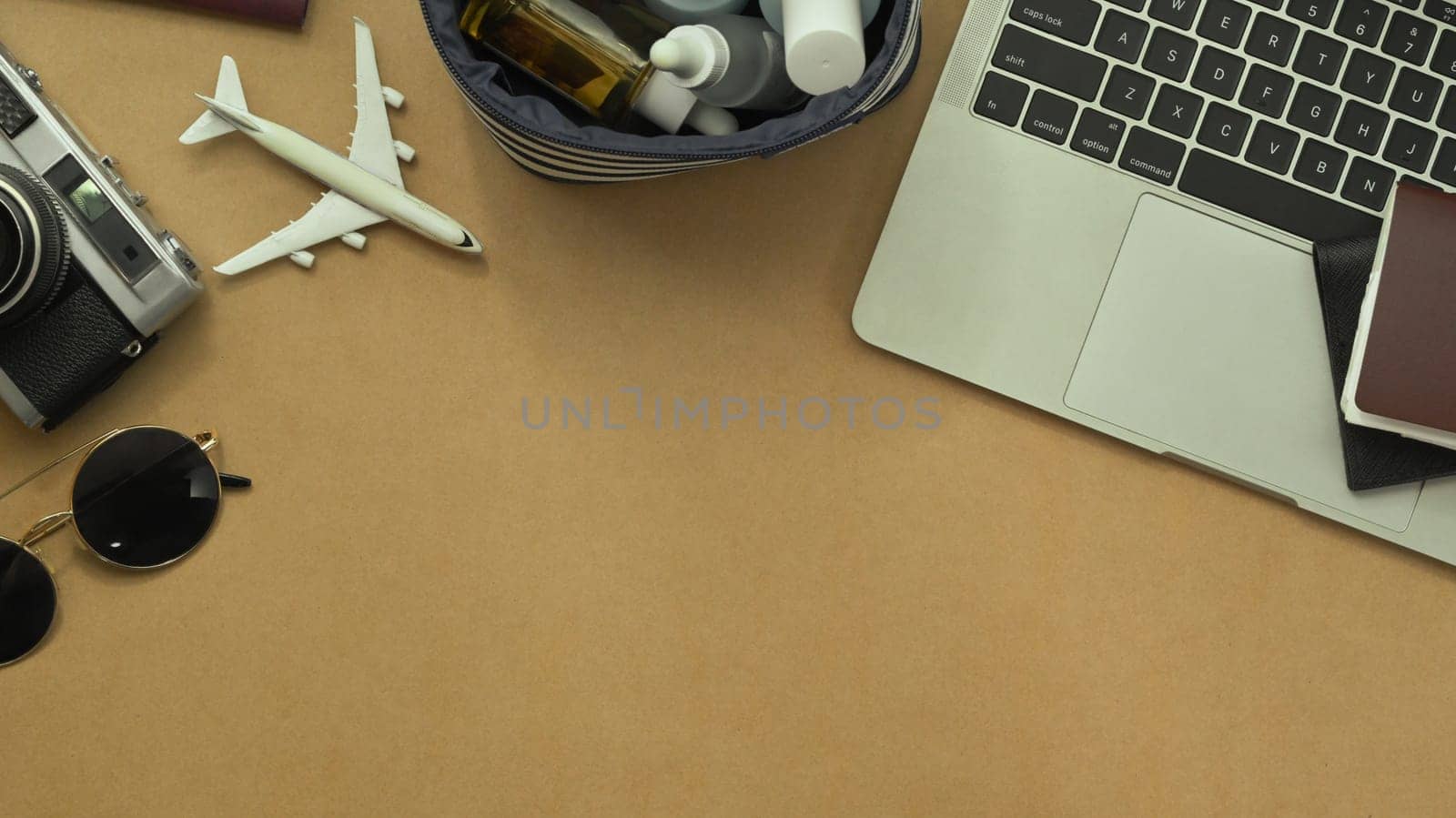 Top view laptop and traveler accessories on brown background. Travel and vacation concept.