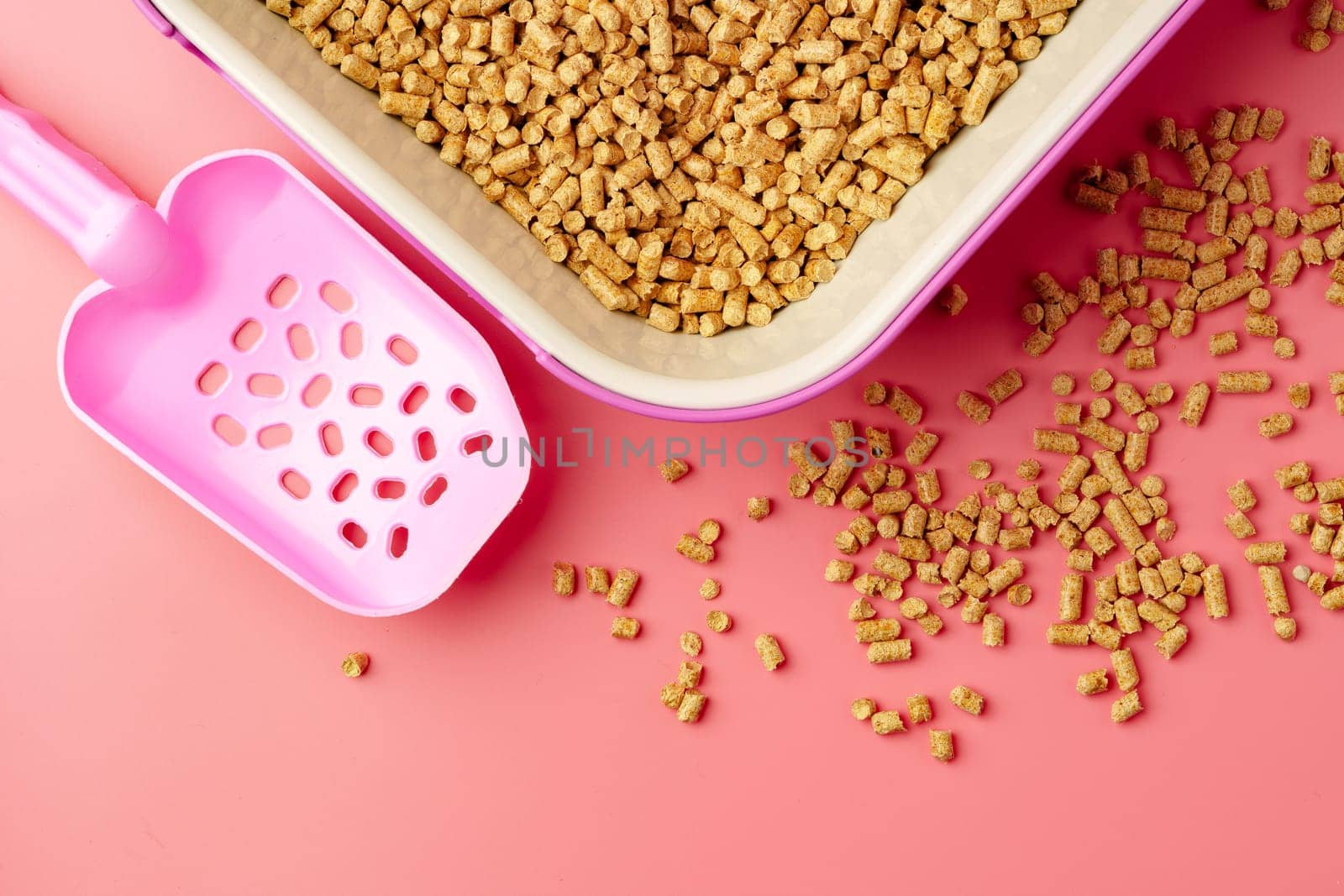 Pet litter box with bio filler on pink background close up