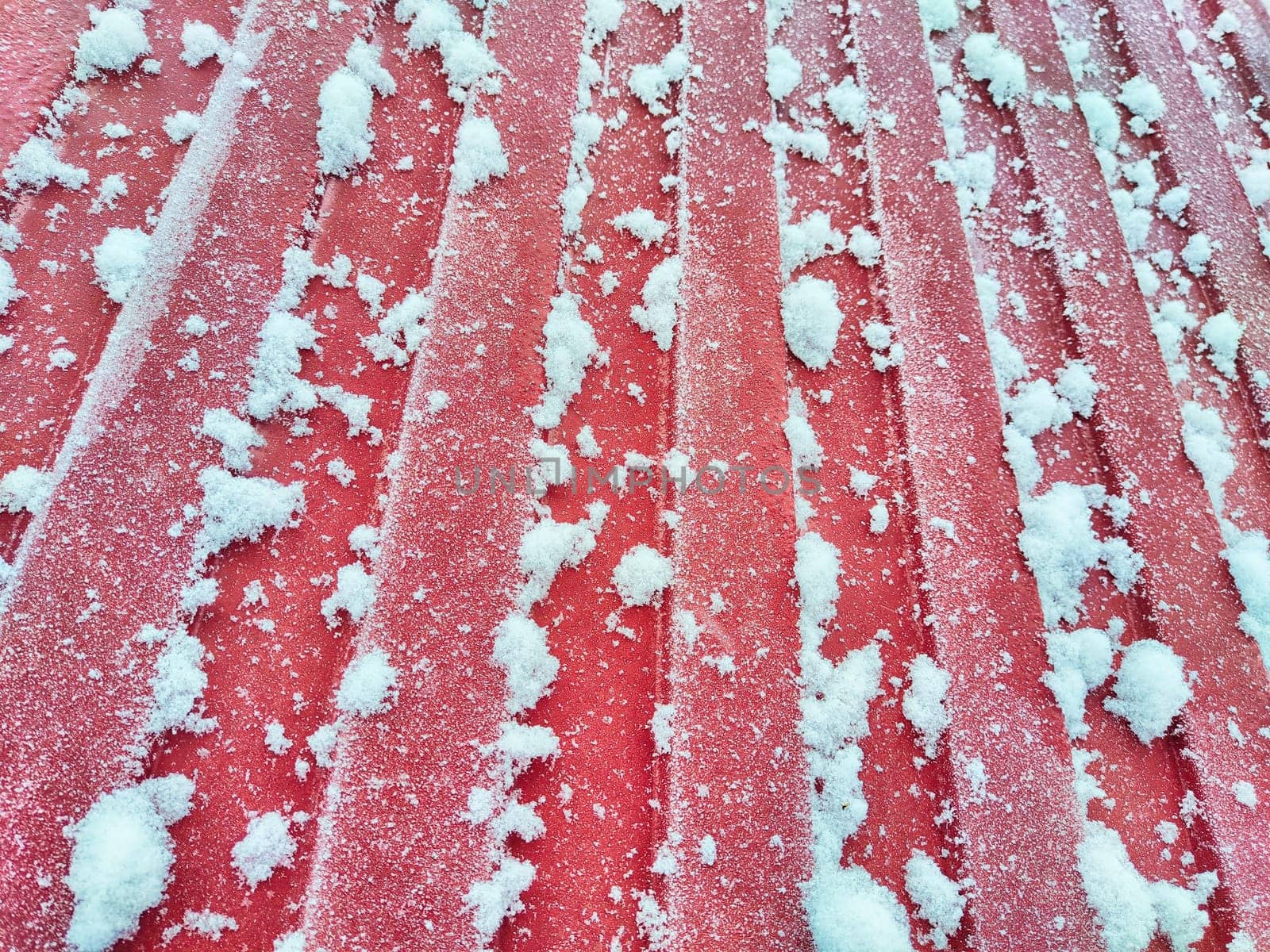 Fence made of galvanized corrugated board in the snow In the village after a snowfall. Abstract background, pattern, texture, place for text and copy space