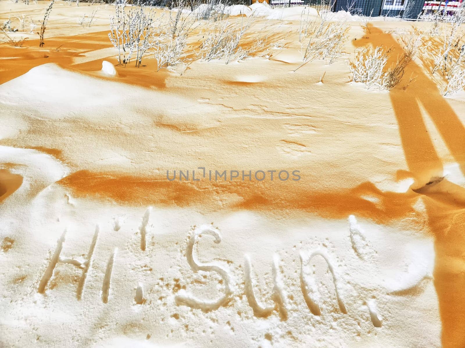 Inscription Hi Summer, written on white background of the snow. Top view. Flat lay. Winter and spring. Waiting for summer and spring