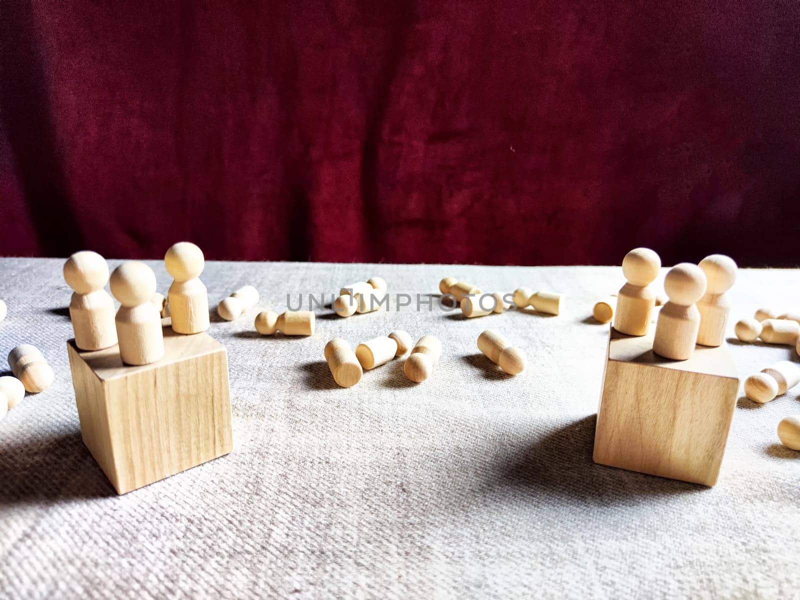 Wooden toys stand opposite and lot of lying figures. Concept of dispute between leaders of two groups. Government and deaths of citizens and soldiers. War in Russia, Ukraine, Israel, Palestine