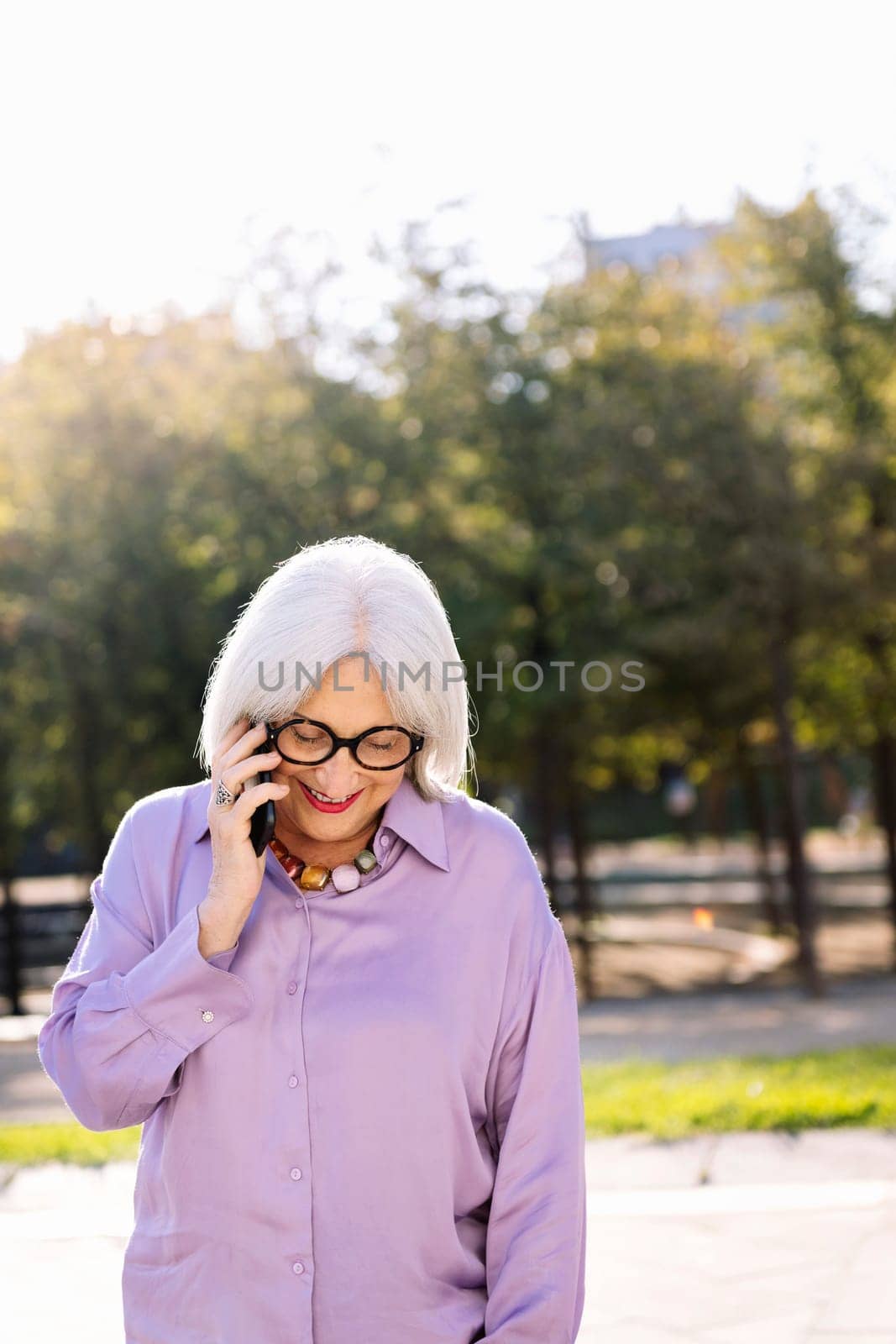 senior woman smiling happy talking by mobile phone by raulmelldo