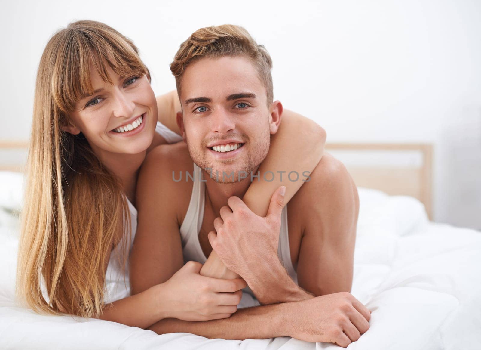 Couple, embrace and portrait in bed on weekend, happy and bonding for love in relationship at home. People, loyalty and commitment to marriage in bedroom, smiling and romance or comfortable in hug by YuriArcurs