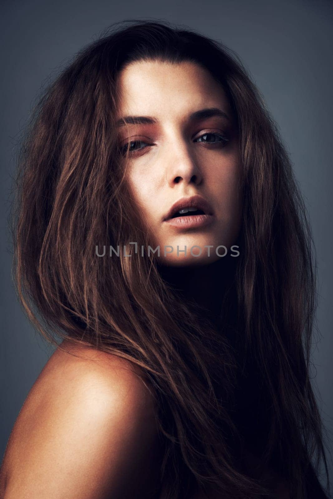 Hair, beauty and portrait of woman on gray background for wellness, healthy texture and growth. Confidence, serious and face of person with hairstyle for shampoo, haircare and cosmetics in studio.