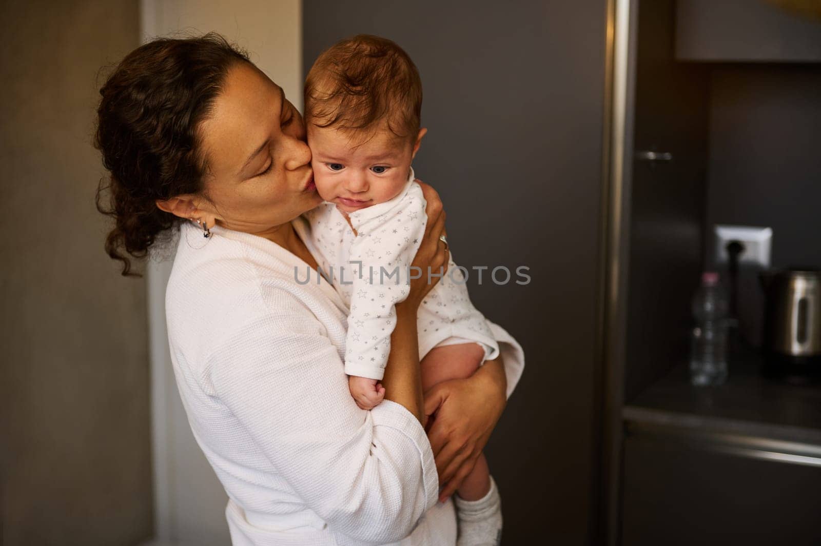 Beautiful young woman, a loving mother hugging her little baby boy at home. . Loving caring mom cuddling her cute child. Happy maternity leave and motherhood lifestyle. People and family concept