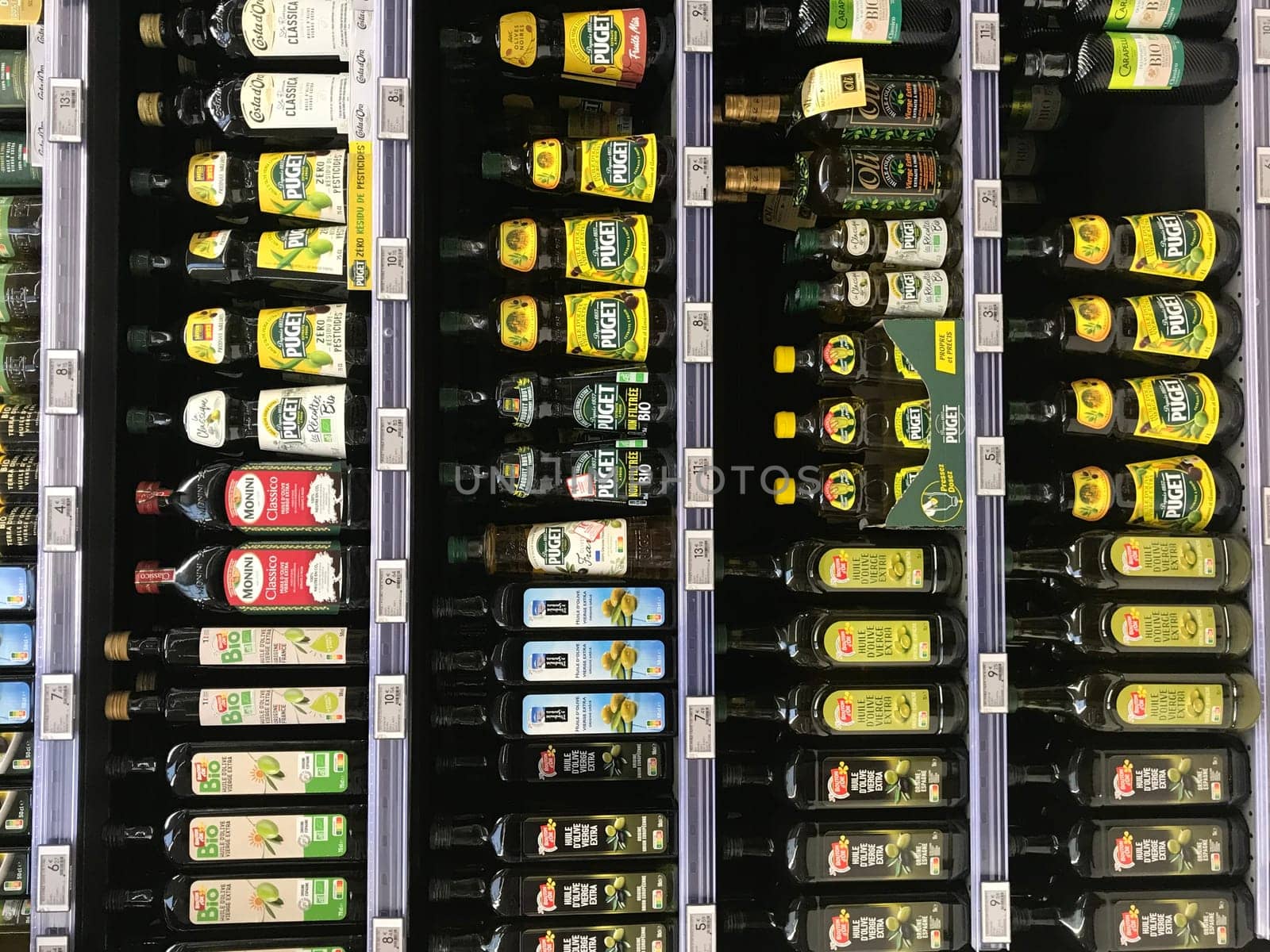 FRANCE, BORDEAUX, February, 2, 2024: Shelving for a large stock virgin olive oil bottles for sale at supermarket. High quality photo