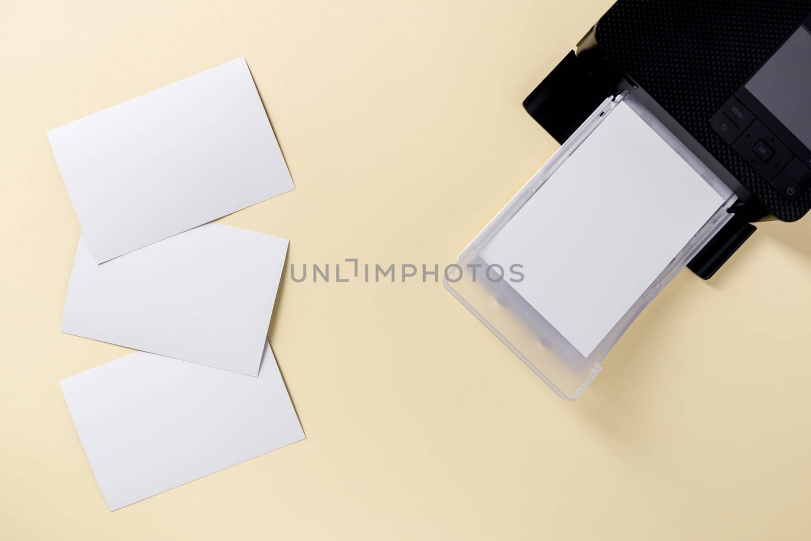 Top view of blank photo papers and mobile photo printer by Sonat