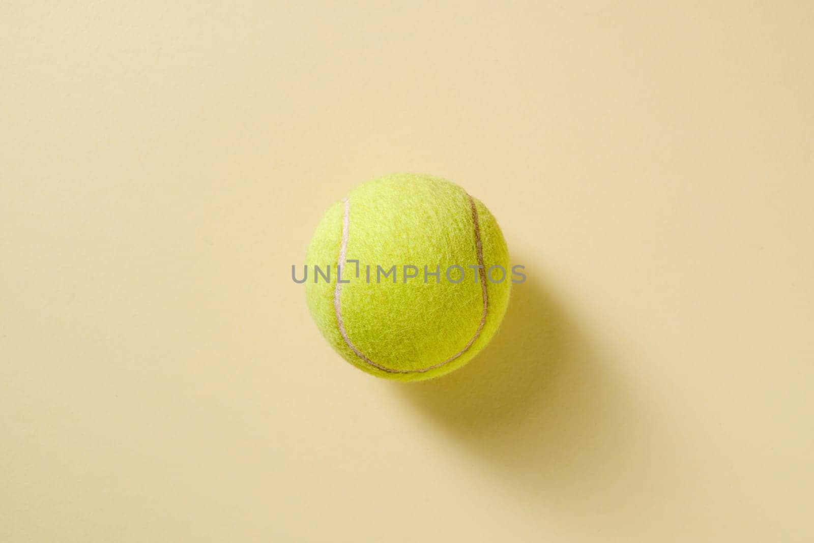 Top view of tennis ball on yellow background