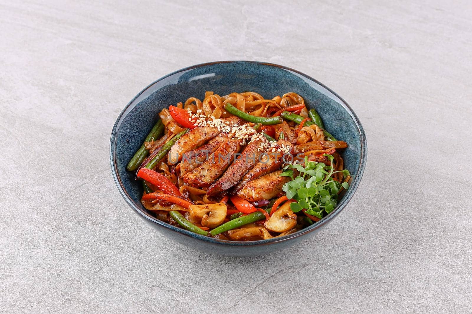 Wok with pork on a stone background studio shooting