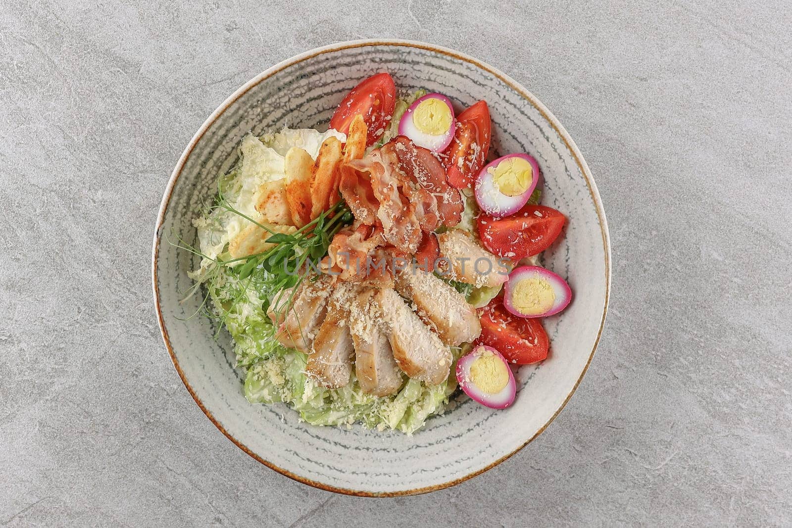 Caesar salad with smoked salmon and pickled eggs on a stone background, studio food photography 4