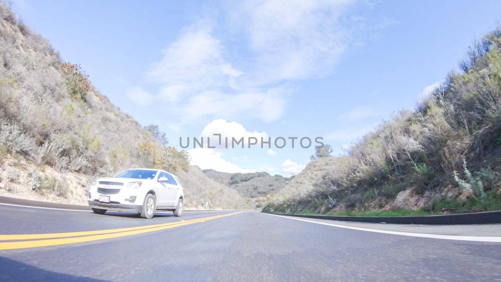 Santa Maria, California, USA-December 6, 2022-Vehicle is cruising along the Cuyama Highway under the bright sun. The surrounding landscape is illuminated by the radiant sunshine, creating a picturesque and inviting scene as the car travels through this captivating area.