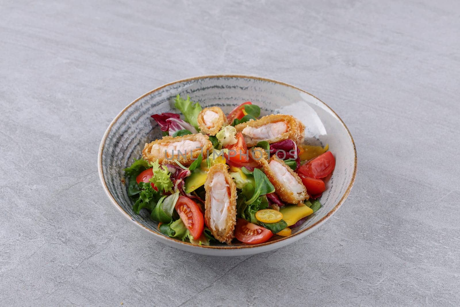 bowl with shrimp in batter, avocado and kumquat on a stone background, studio food photography 1