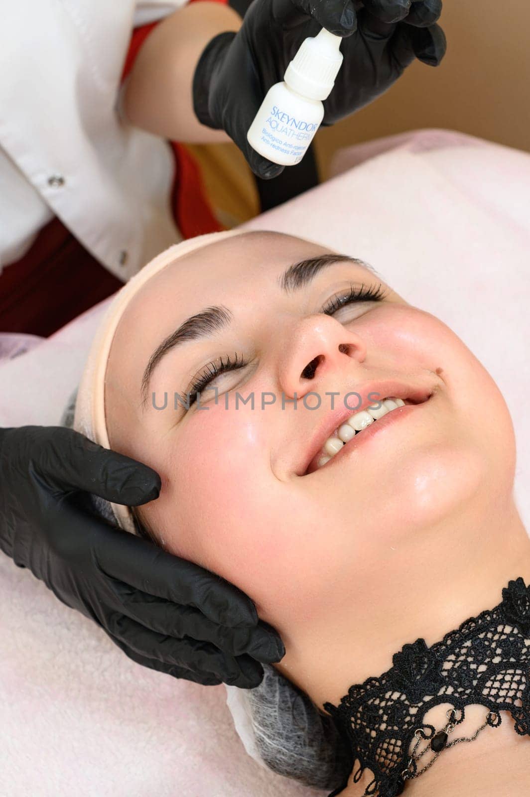 A cosmetologist applies couperosis cream to a girl's face, a procedure to reduce couperosis on the face. Ivano-Frankivsk, Ukraine May 17, 2023