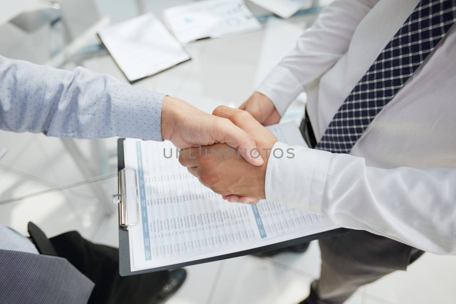 Close-up image of businesspeople shaking hand during the the meeting. by Prosto