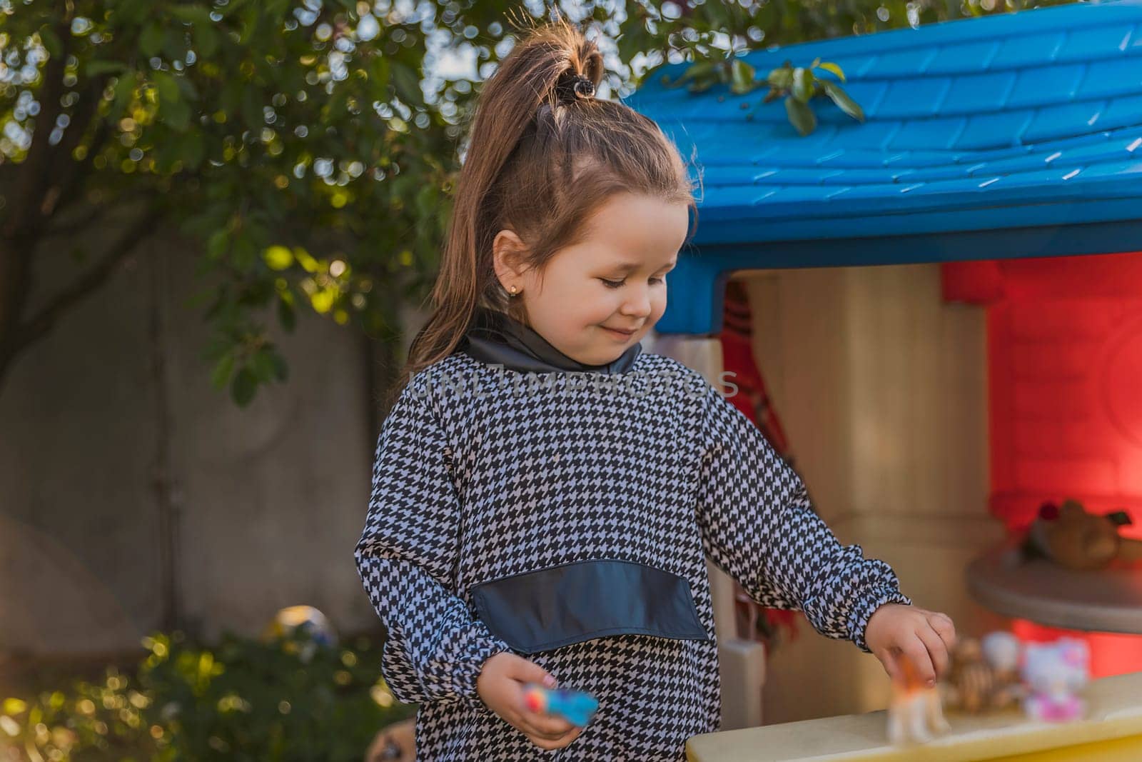 portrait of a little girl playing outdoors near her house