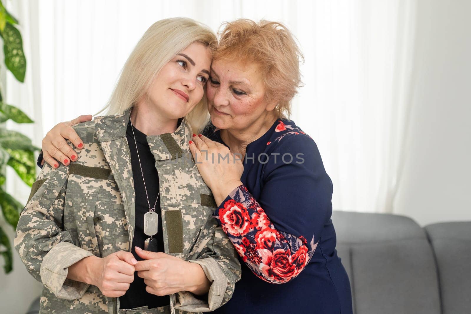 Soldier woman returning home to her family, embracing his mother, close up by Andelov13