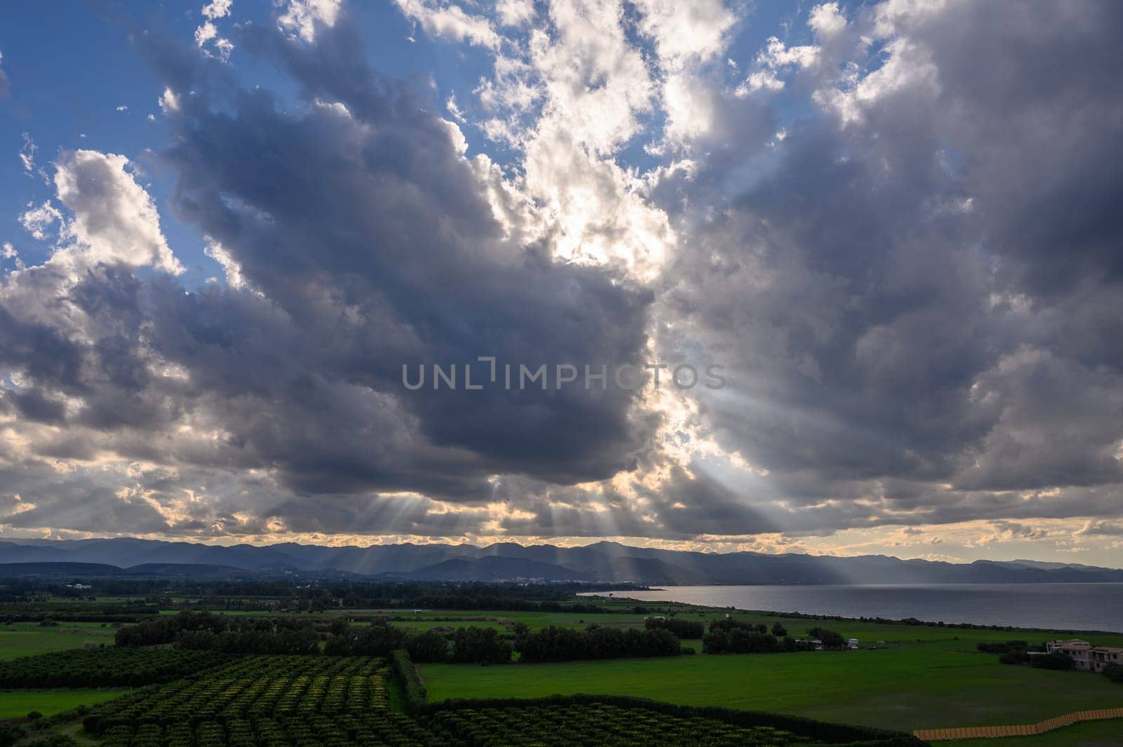 sun rays through dramatic clouds over mountains and sea in cyprus 2