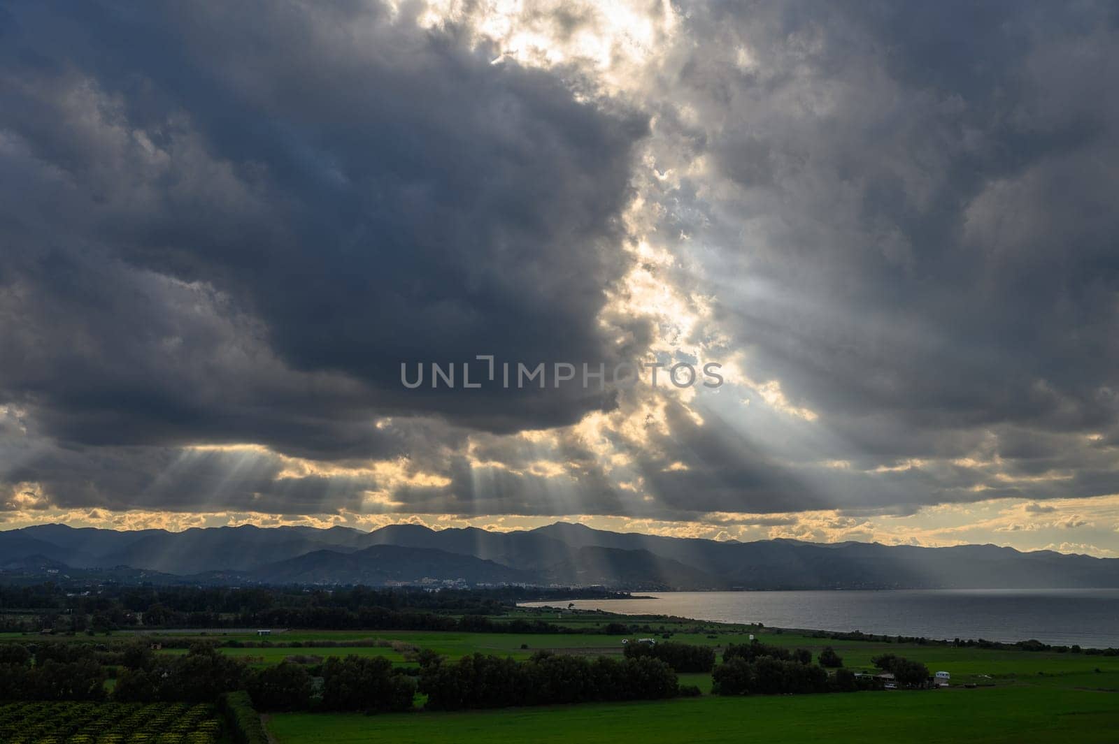 sun rays through dramatic clouds over mountains and sea in cyprus 5