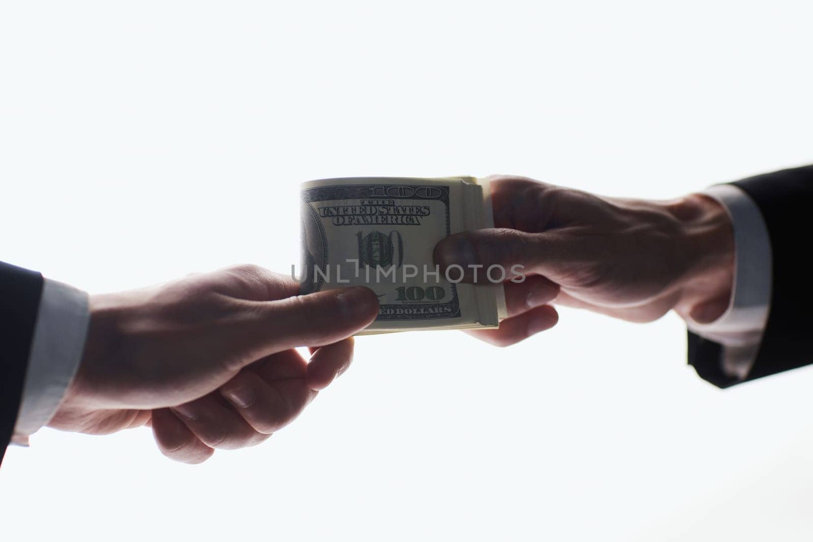 Man offering batch of hundred dollar bills. Hands close up.