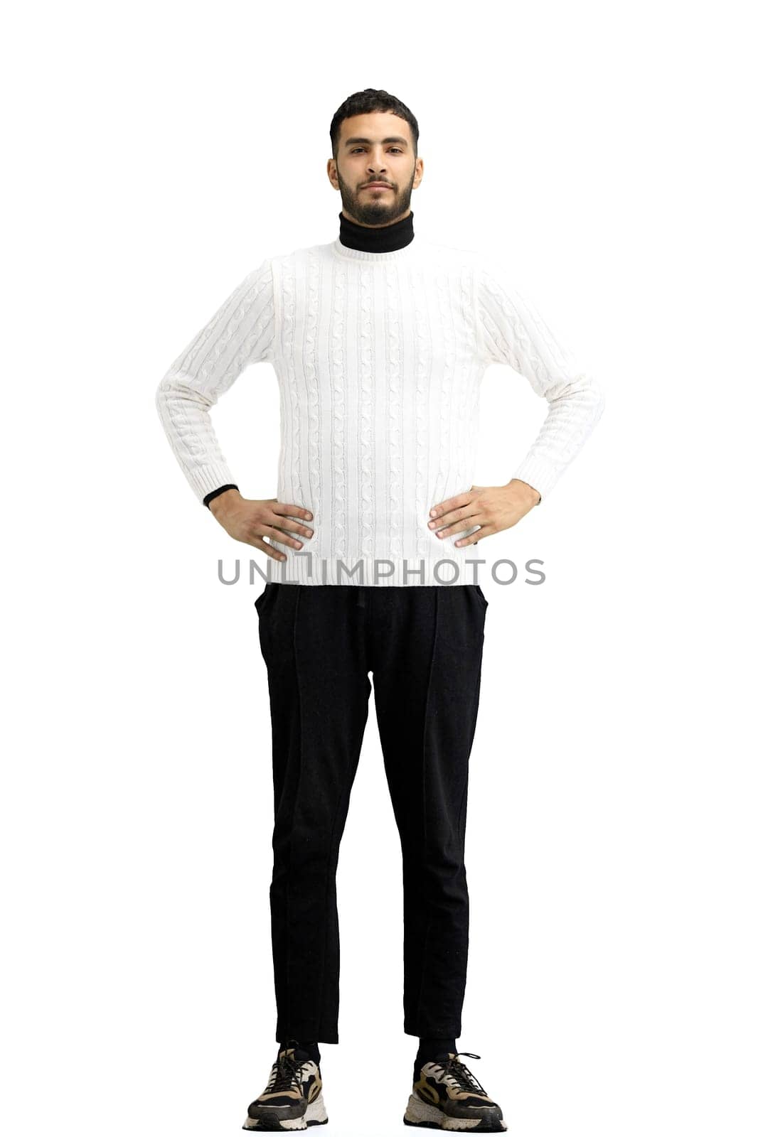 Man, full-length, on a white background, hands on hips.