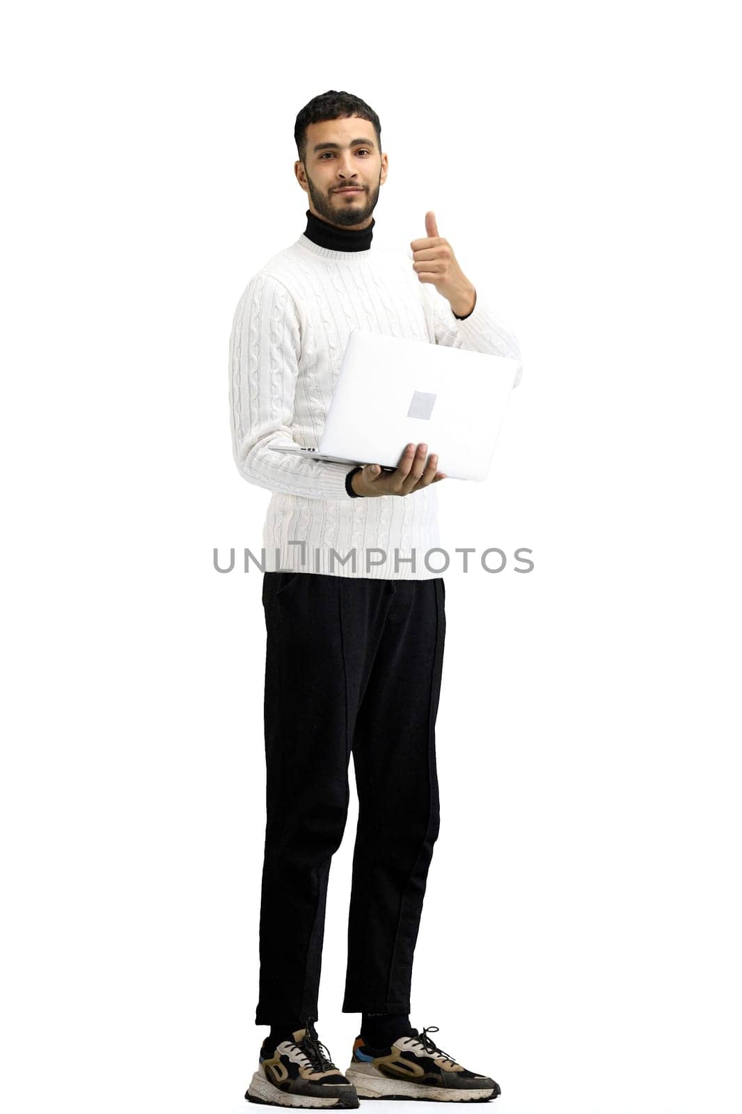 A man, full-length, on a white background, uses a laptop.