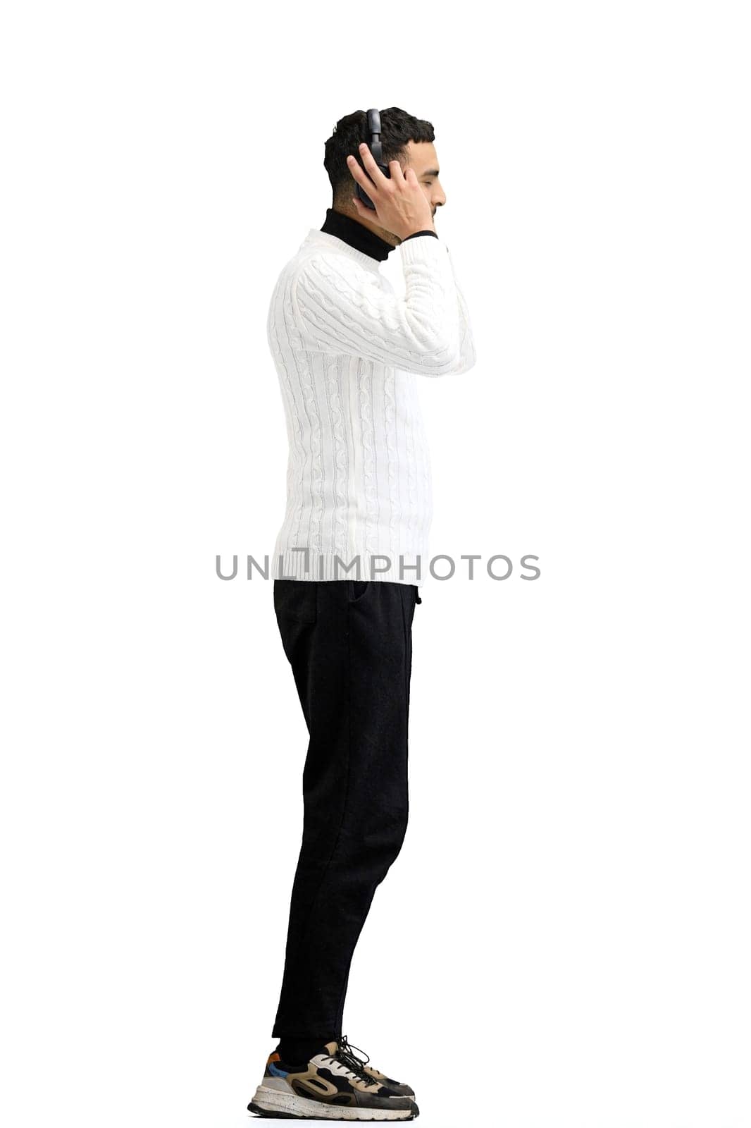 A man, full-length, on a white background, listening to music in headphones by Prosto