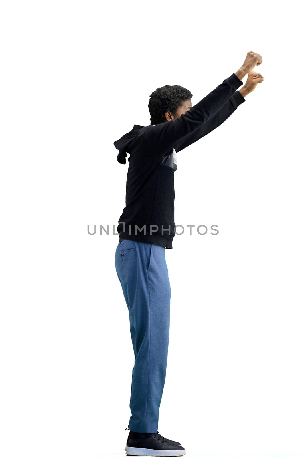 A man, full-length, on a white background, raised his hands up.