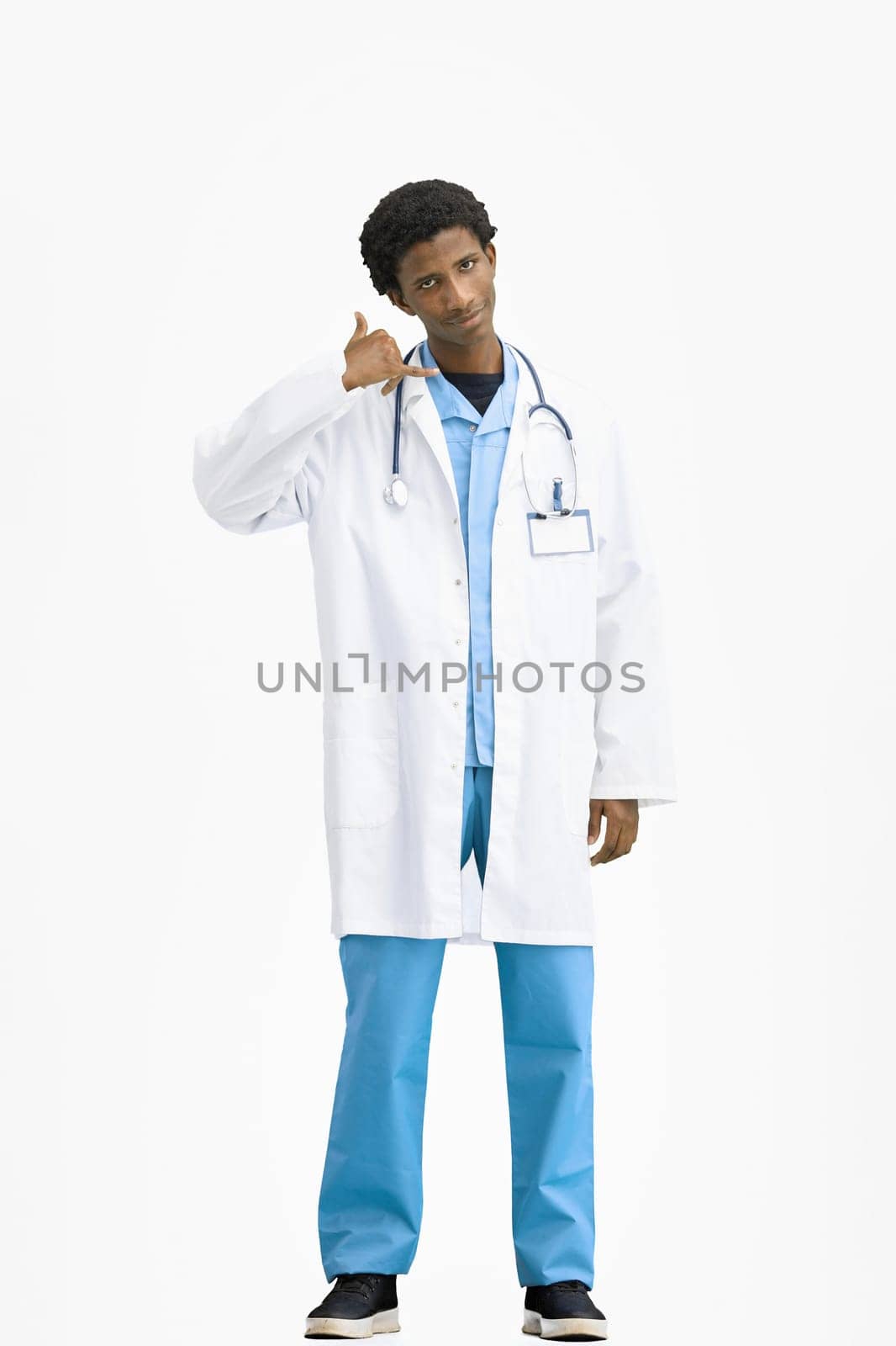 The doctor, in full height, on a white background, shows a call sign.