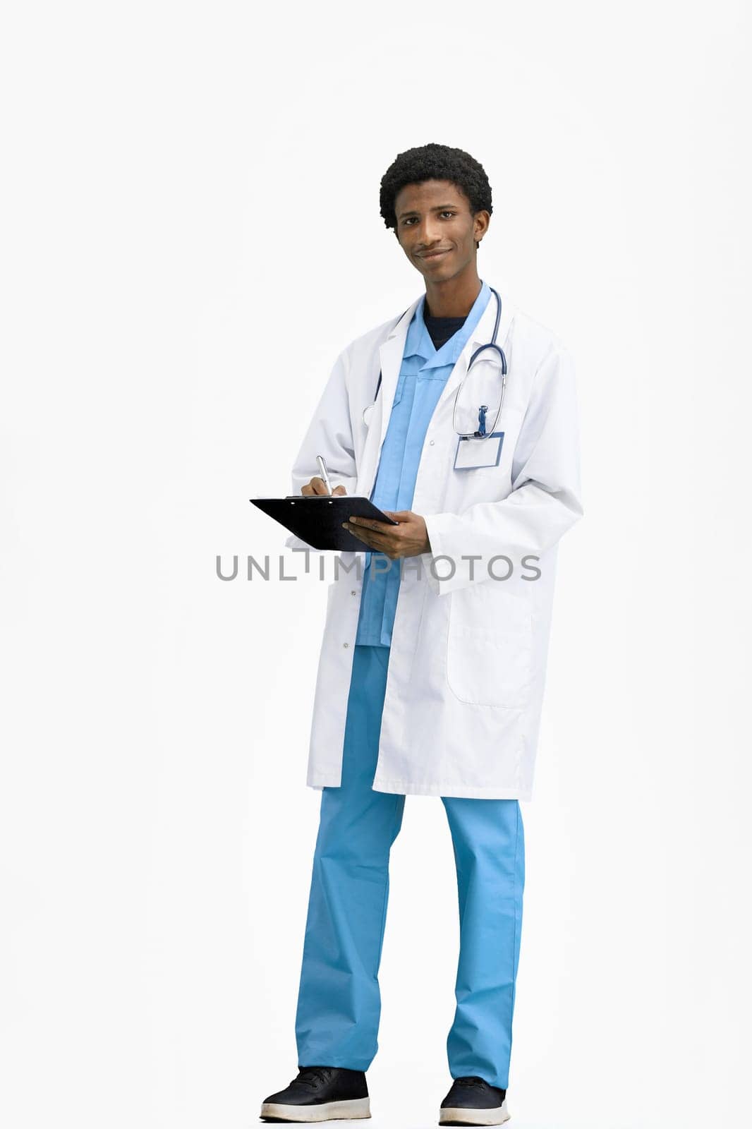 The doctor, in full height, on a white background, writes.