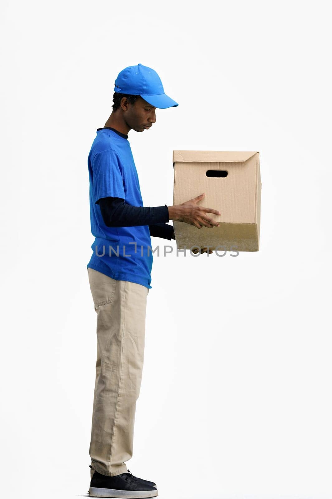 The deliveryman, in full height, on a white background, examines the box by Prosto