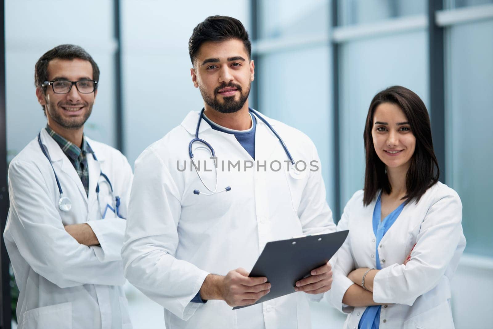 Three medical colleagues stand in the lobby of the hospital
