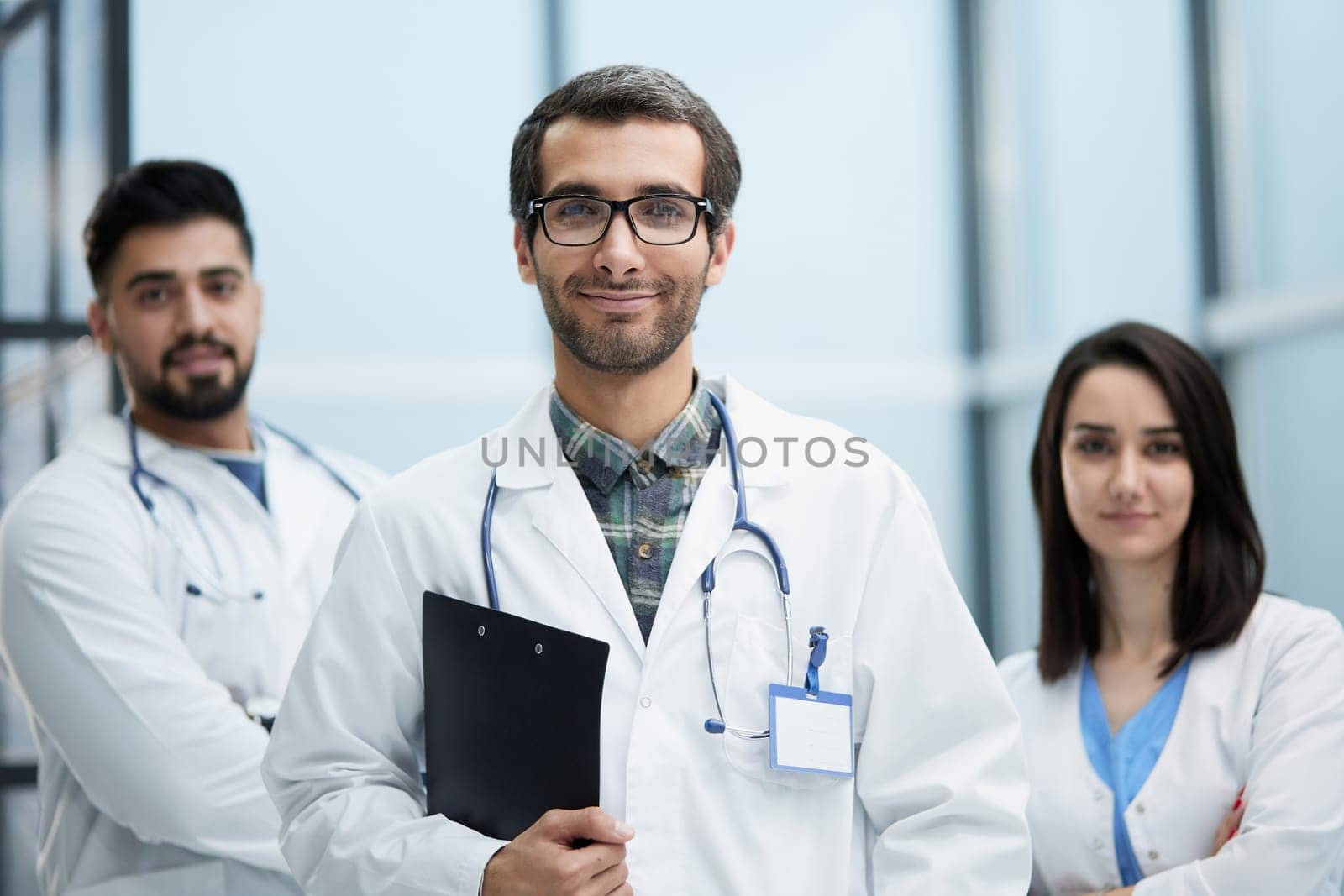 Portrait of three clinicians in uniform looking at camera with smiles