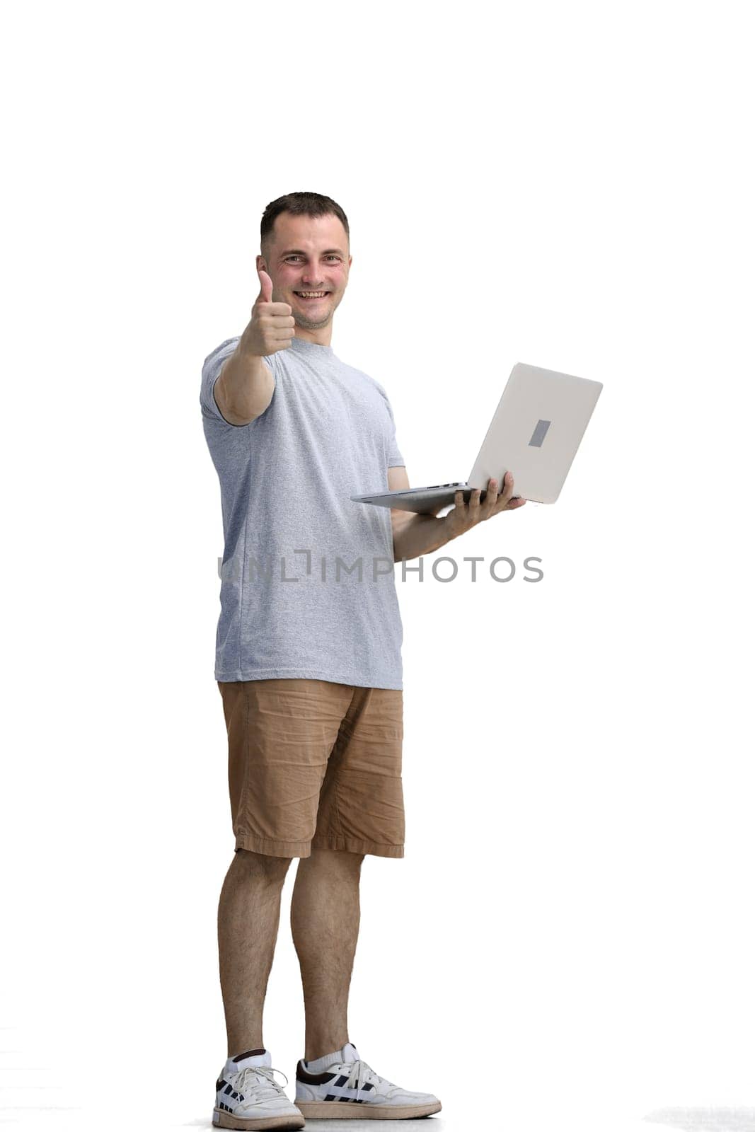 A man in a gray T-shirt, on a white background, in full height, uses a laptop by Prosto